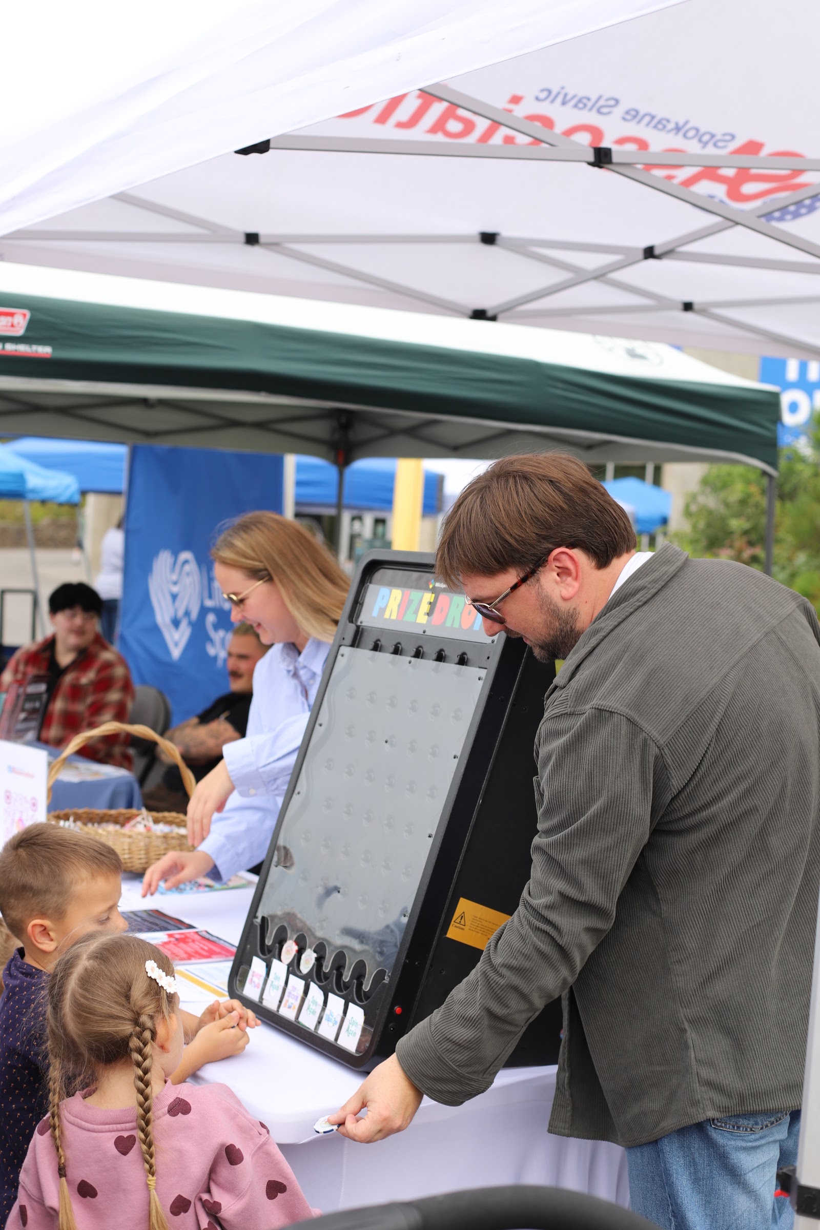 SSA staff engaging with children at the Spokane Slavic Association tent during Hands Across Spokane, a community resource fair.