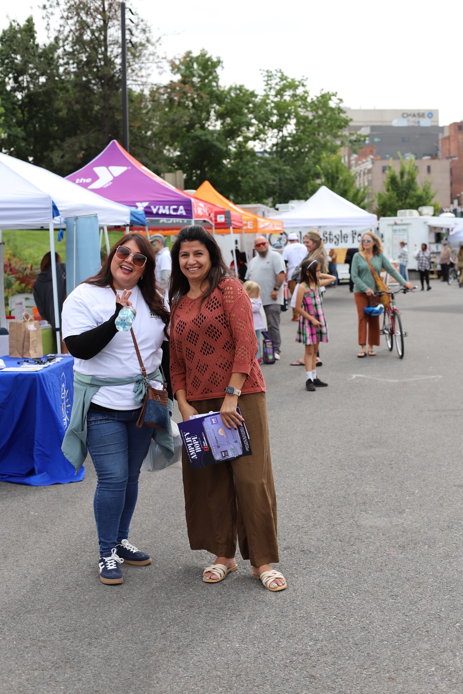 Families walk among sponsor and partner tents at a community event in Spokane.