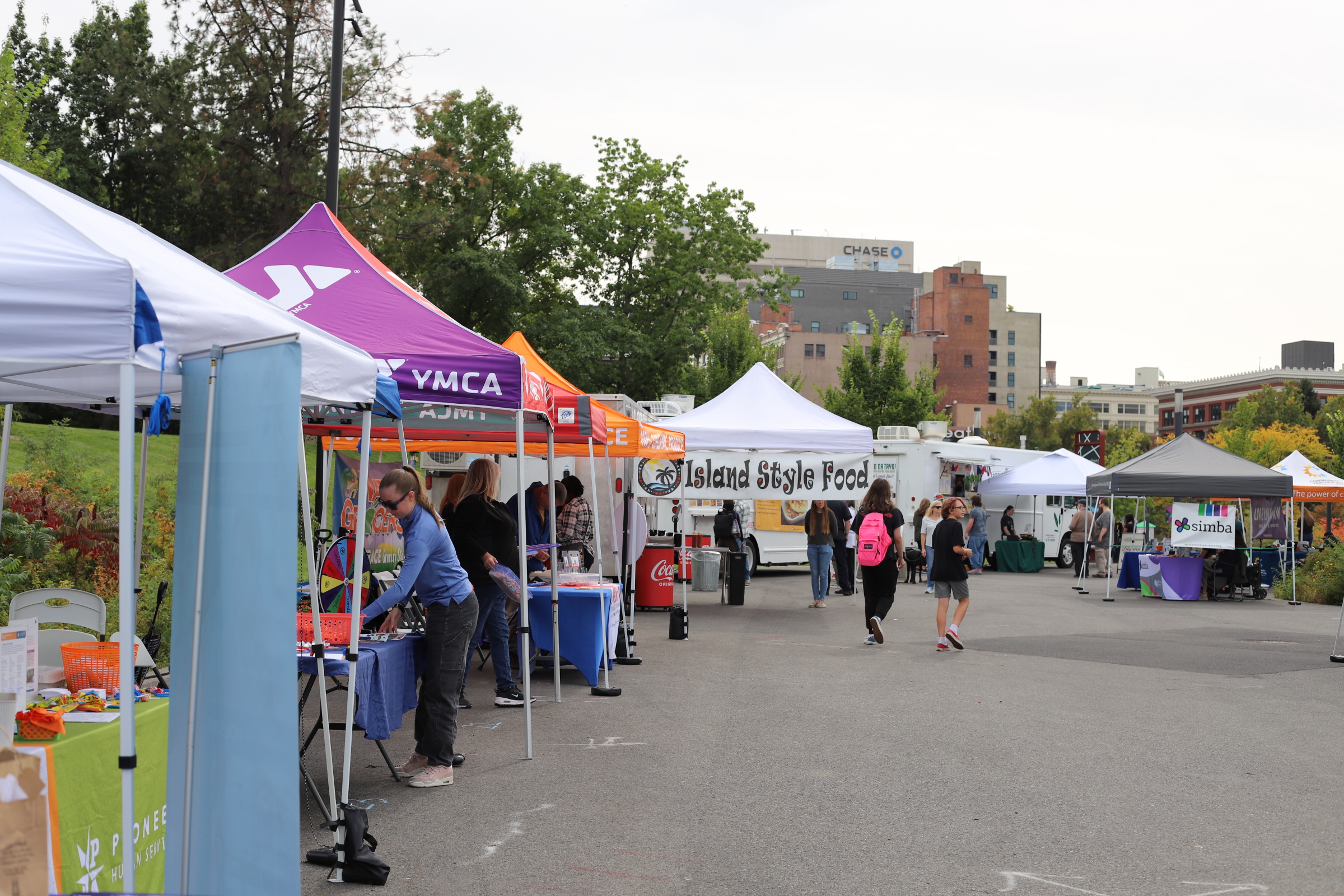 A row of resource-fair tents and food trucks from partner organizations at Hands Across Spokane.