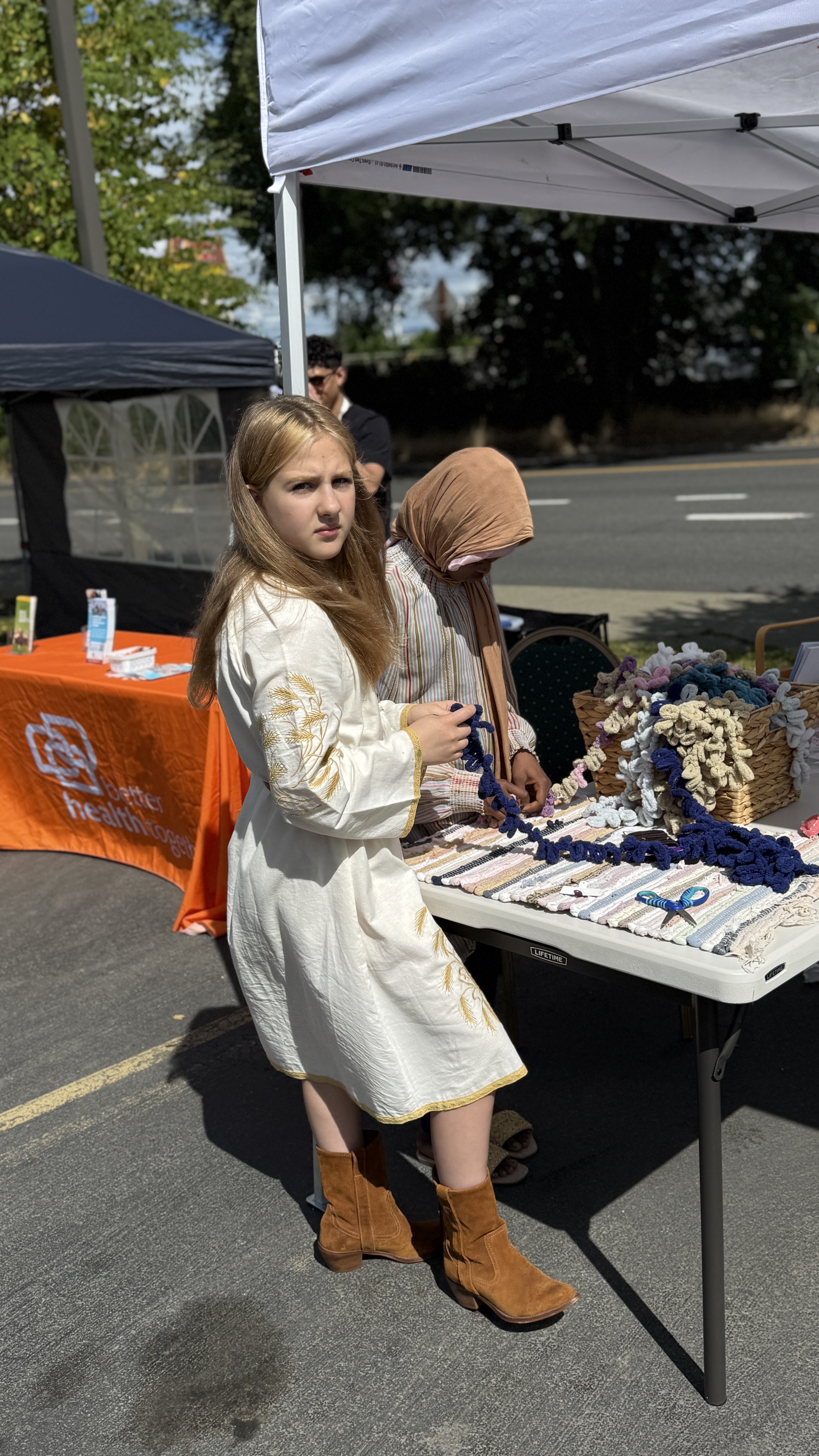 A volunteer shares information at an outreach table during Refugees Day.
