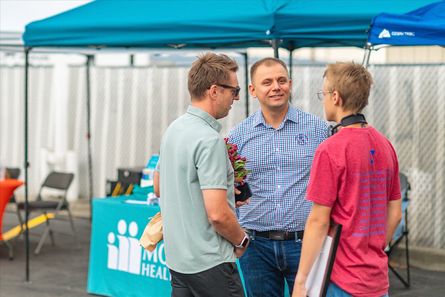 Three community members in an attentive conversation at an SSA event.