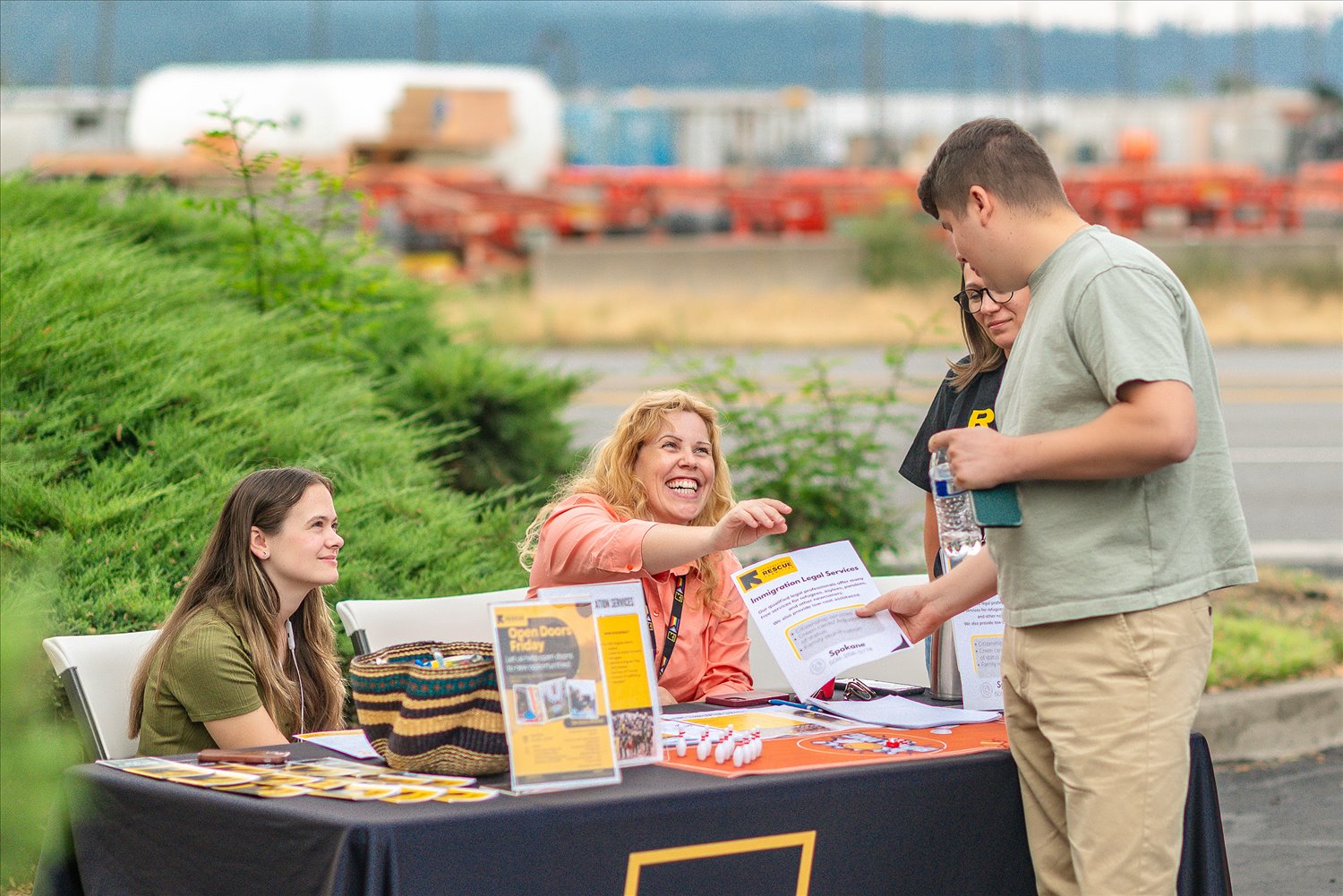 A family receiving information from a community partner organization's resource table at an SSA event.