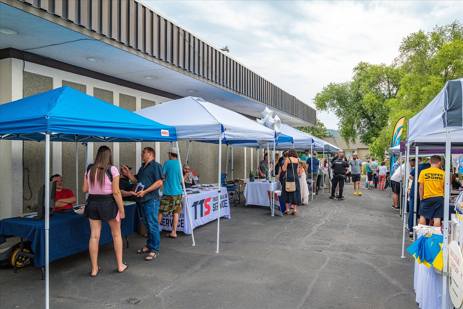 Community members and vendors at tents during an SSA outreach event.